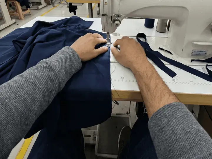 Hands adjusting fabric on the sewing machine